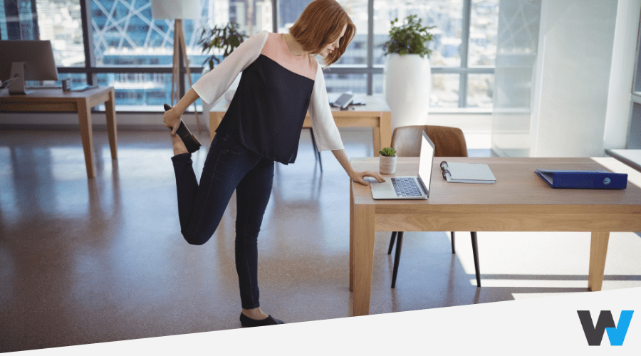 Woman stretching while working on her laptop