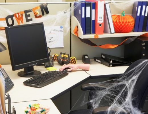cubicle decorated for halloween with pumpkins and spiderwebs