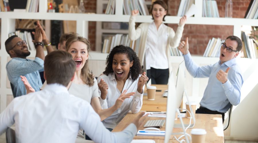 group of happy professionals cheering and clapping