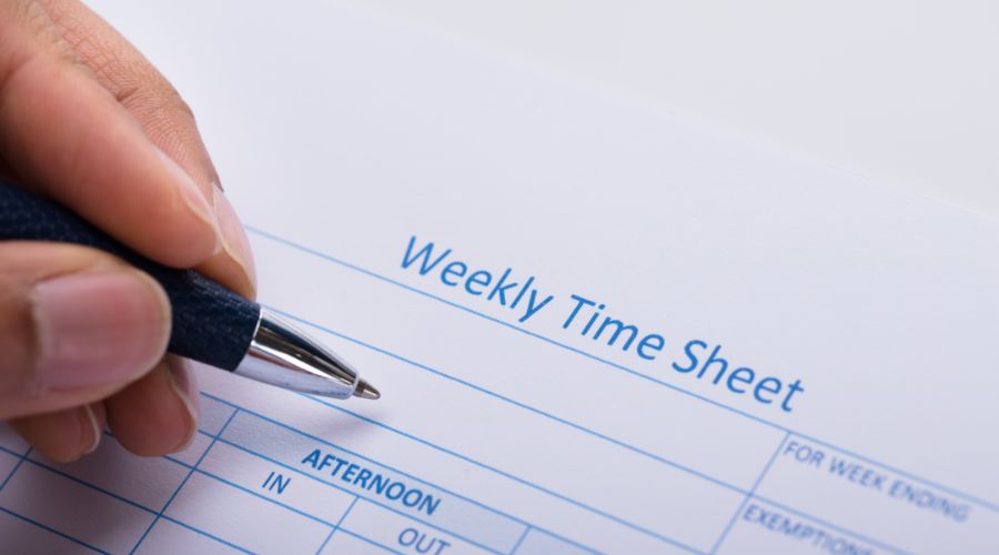 person filling out a weekly time sheet