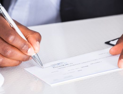 close-up of small business owner signing paycheck